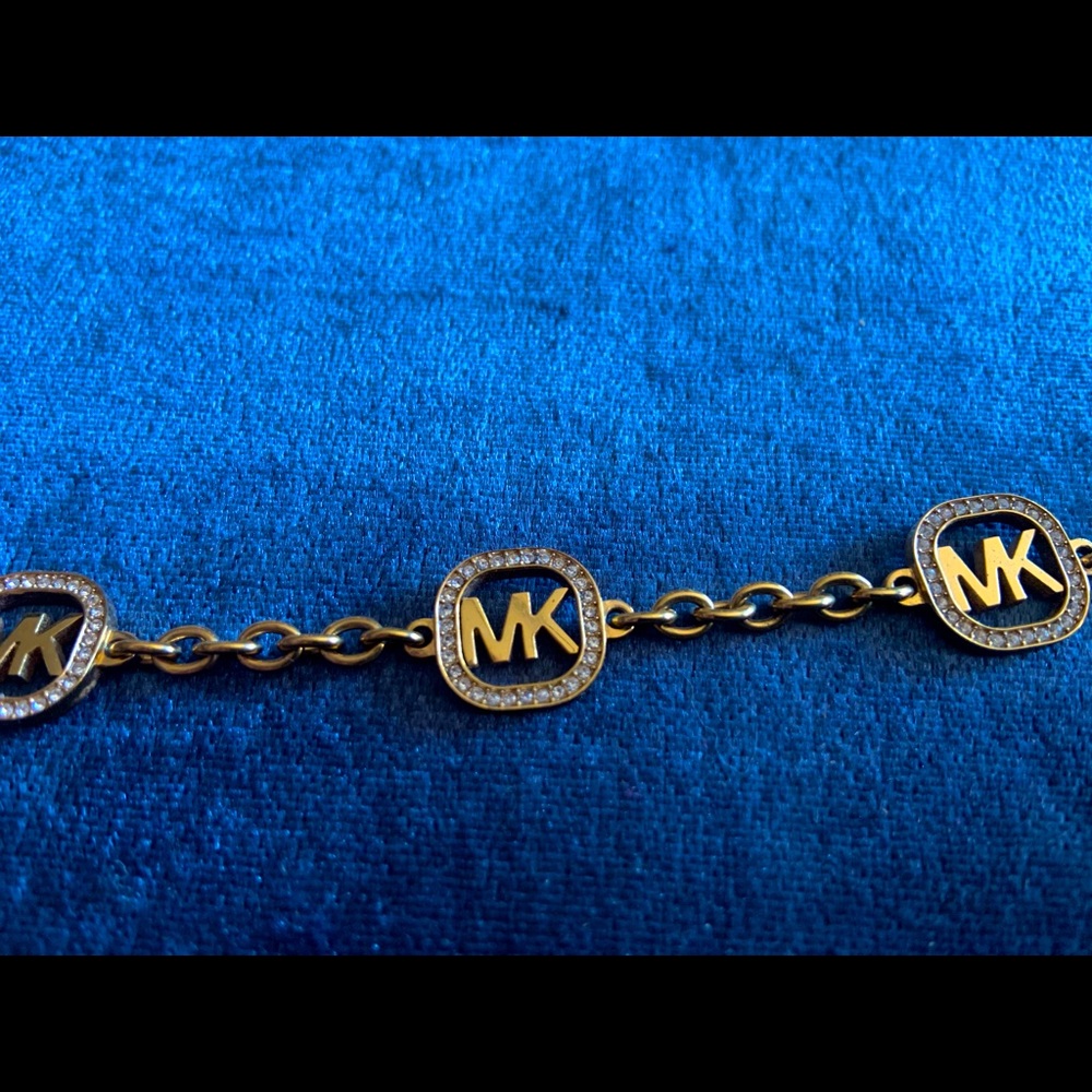 MICHAEL KORS gold tone stainless steel logo bracelet with crystal embellishments